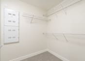 Thumbnail 63 of 137 - A white wall with a metal rack and a white cabinet with drawers.