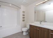Thumbnail 51 of 137 - A white bathroom with a toilet, sink, and bathtub.