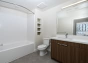 Thumbnail 66 of 137 - A white bathroom with a toilet, sink, and bathtub.
