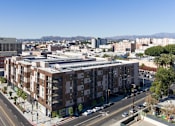 Thumbnail 18 of 26 - A city street with apartment buildings and cars at Wilshire Valencia Apartment, Los Angeles