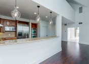 Thumbnail 42 of 44 - an open kitchen and living room with white walls and wood floors at Vendome Place, San Jose