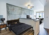 Thumbnail 34 of 44 - a bedroom with a bed and a wall with a concrete wall behind it at Vendome Place, San Jose, 95110