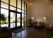 Thumbnail 27 of 44 - Pet-Friendly Apartments in Downtown San Jose, CA - Vendome Place - Lobby with Glass Door, Glass Wall, High Ceiling, Seating Area, and Receptionist Window.