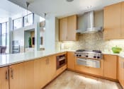 Thumbnail 2 of 51 - Apartments Kitchen With Wooden Cabinetry And Multi-Colored Tile Backsplash at Venue, San Francisco, CA