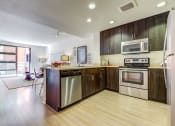 Thumbnail 9 of 51 - San Fransisco Luxury Apartments - Modern Kitchen with Stainless Steel Appliances, Wood-Style Flooring, Modern Décor, And Sliding Glass Door.