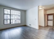 Thumbnail 26 of 51 - an empty living room with a large window and wood flooring at Venue, San Francisco, CA