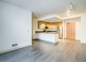 Thumbnail 27 of 51 - the living room and kitchen of an empty apartment with wood flooring at Venue, San Francisco, CA