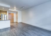 Thumbnail 28 of 51 - the living room and kitchen of an apartment with wood floors and white walls at Venue, San Francisco, 94158