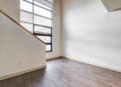 Thumbnail 32 of 51 - an empty living room with wood flooring and a large window in the loft space at Venue, San Francisco, California