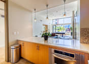 Thumbnail 39 of 51 - A modern kitchen with wooden cabinets and a stainless steel oven.