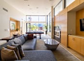 Thumbnail 42 of 51 - A modern living room with a grey couch and a large window.