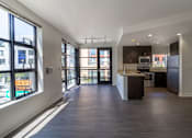 Thumbnail 48 of 51 - A spacious kitchen and living room with dark wood floors and white walls.