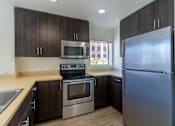 Thumbnail 51 of 51 - A kitchen with a stainless steel refrigerator, oven, and microwave.