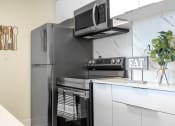 Thumbnail 22 of 39 - Kitchen with white cabinets with stainless appliances at Vera Cortez Hill, San Diego, CA