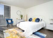 Thumbnail 11 of 39 - bedroom with white nightstand and light, large windows at Vera Cortez Hill, San Diego, CA, 92101
