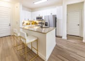 Thumbnail 17 of 34 - a kitchen with white cabinets and a granite counter top at Waterford RiNo, Denver, CO