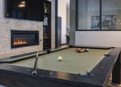 Thumbnail 8 of 34 - a pool table in the clubroom with a firepit at Waterford RiNo, Colorado 80216