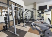 Thumbnail 13 of 34 - a gym with weights and a tv on the wall at Waterford RiNo, Denver, Colorado