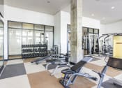 Thumbnail 14 of 34 - a gym with weights and cardio equipment on the floor and windows at Waterford RiNo, Denver, 80216