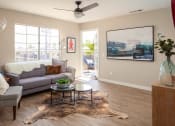 Thumbnail 12 of 16 - Living room with large windows and door to balcony at Driftwood, San Diego