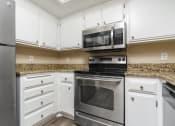 Thumbnail 34 of 52 - Gourmet Kitchen with Hardwood-Style Flooring, Sandy Granite Countertops, White Cabinetry, and Stainless Steel Appliances. at Westlake Canyon, Thousand Oaks, 91362