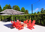Thumbnail 19 of 46 - Outdoor seating with umbrella at Woodlake Apartments, Kirkland