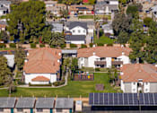 Thumbnail 24 of 81 - Aerial view of residential buildings with solar panels at Woodbend Apartments, Alta Loma, CA 91701