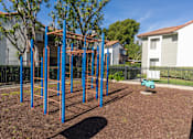 Thumbnail 17 of 81 - Outdoor fitness equipment with monkey bars and rings at Woodbend Apartments, Alta Loma, California