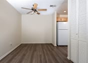 Thumbnail 52 of 81 - Empty living room with ceiling fan and kitchen at Woodbend Apartments, Alta Loma, CA 91701