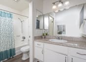 Thumbnail 63 of 81 - Bathroom with white vanity and granite countertop at Woodbend Apartments, California, 91701