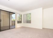 Thumbnail 21 of 40 - Living room with windows and balcony door at Woodbend, Alta Loma, CA