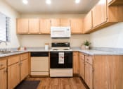Thumbnail 25 of 40 - Kitchen with Wooden Cabinets and Granite-Style Countertops at Woodbend, Alta Loma