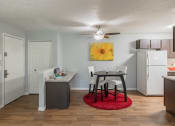Thumbnail 3 of 20 - a kitchen and dining area with a small table and a refrigerator