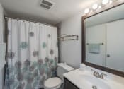Thumbnail 8 of 20 - a bathroom with a shower and a sink and a toilet