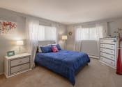 Thumbnail 6 of 20 - a bedroom with a bed and a dresser