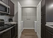 Thumbnail 35 of 38 - A kitchen with dark wood cabinets and a white refrigerator.