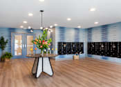 Thumbnail 7 of 10 - A room with a round table and a flower arrangement on it.