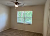 Thumbnail 12 of 15 - an empty room with a large window and a ceiling fan
