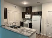 Thumbnail 7 of 15 - a kitchen with a white refrigerator freezer next to a stove top oven