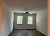 Thumbnail 9 of 15 - an empty room with a ceiling fan and two windows