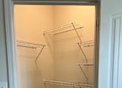 Thumbnail 4 of 15 - a walk in closet with white walls and a large mirror