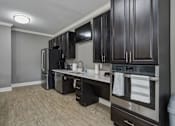Thumbnail 8 of 38 - A kitchen with dark wood cabinets and stainless steel appliances.