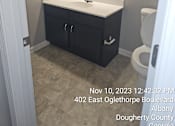 Thumbnail 13 of 14 - A bathroom with a toilet, sink, and mirror.
