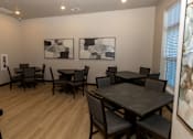 Thumbnail 10 of 10 - A room with a table and chairs and two pictures on the wall.