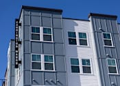 Thumbnail 1 of 10 - The Carrington Manor building has a grey and white exterior.