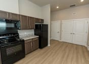Thumbnail 7 of 10 - A kitchen with black appliances and wooden cabinets.