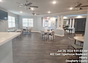 Thumbnail 7 of 14 - A spacious room with tables and chairs is shown with a timestamp and location information.