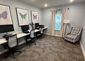 Thumbnail 3 of 6 - A room with a carpeted floor and a desk with chairs.