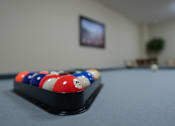 Thumbnail 13 of 38 - A pool table with a red, white and blue ball on it.
