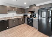 Thumbnail 1 of 8 - A kitchen with a black refrigerator, black oven, and black dishwasher.